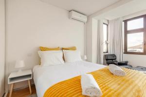 1 dormitorio con 1 cama grande con manta amarilla en I Love Vila do Conde, en Vila do Conde
