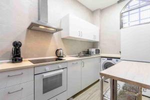 a white kitchen with a sink and a dishwasher at Luxury apartamento Sevilla centro -triana in Seville