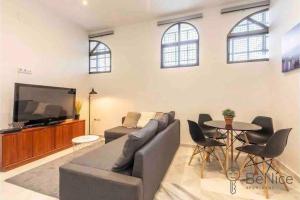 a living room with a couch and a tv and a table at Luxury apartamento Sevilla centro -triana in Seville +7 photos
