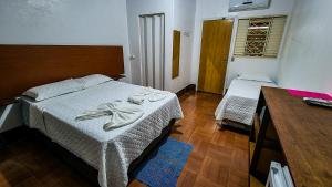 1 dormitorio con 1 cama con toallas en Pousada Portal, en Chapada dos Guimarães