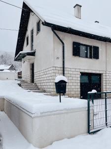 a snow covered house with a parking meter in front of it at Holiday House Smilja in Ogulin