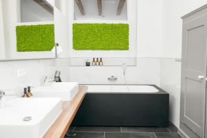 a bathroom with two sinks and a bath tub at HEIMATEL - Luxury Penthouse Loft in Ravensburg