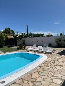 una piscina en un patio con sillas y una valla en Casa Mar- 12 km de Maceió, en Maceió