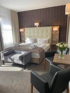 ein Hotelzimmer mit einem großen Bett und zwei Stühlen in der Unterkunft zur altstadt in Weida