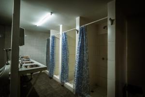 a bathroom with a sink and blue shower curtains at Anum Hostel in Ushuaia