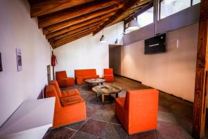 sala de estar con mesa y sillas de color naranja en Anum Hostel en Ushuaia