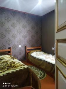 two beds in a room with purple walls at Quba Guest House 