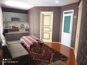 a living room with a couch and a table at Quba Guest House in Digah