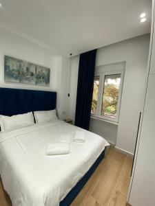a bedroom with a white bed and a window at Apartament in Blloku in front of Taiwan in Tirana