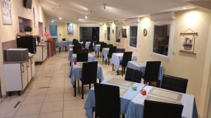 une salle à manger avec des tables et des chaises ainsi que des tables bleues et des chaises dans l'établissement Hôtel Estuaire, à Saint-Brévin-les-Pins