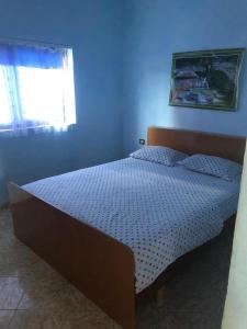 una camera da letto con un letto in una stanza blu di Velipoja Family Apartment a Velipojë