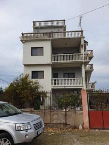 una macchina bianca parcheggiata di fronte a un edificio di Velipoja Family Apartment a Velipojë 1 altra foto