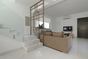 a living room with a couch and a staircase at Villa Harmonia in Protaras