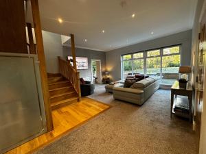 a large living room with a couch and a staircase at The Buckie at Buchanan in Drymen