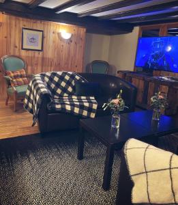 a living room with a couch and a tv at Auberge "La Petite Auberge" in Bourg-Saint-Maurice