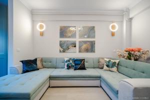 a living room with a blue couch with pillows at Bliss Land Luxury Apartments in Gura Humorului