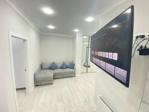 een woonkamer met een bank en een flatscreen-tv bij Avram Iancu Residence New Apartments in Chişinău