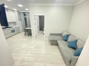 een woonkamer met een bank en een keuken bij Avram Iancu Residence New Apartments in Chişinău
