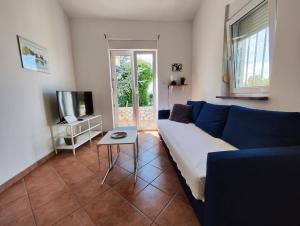 a living room with a blue couch and a tv at Lavender House in Mandre