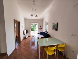 a living room with a table and yellow chairs at Lavender House in Mandre