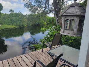 a table and chairs on a deck next to a river at 1. Great room for rent, Individual entrance, private bathroom, beautiful lake, in manufactured home, 5 min from Hard Rock Hotel Casino in Davie