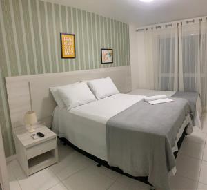 MANDAI Apartamento Cabo Frio في كابو فريو: غرفة فندقية بسرير وموقف ليلي