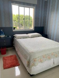 a bedroom with a bed with a window and a rug at Apto com conforto que você precisa. in Goiânia