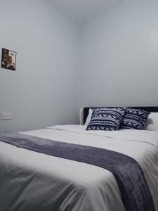 Una cama con almohadas azules y blancas. en Epic homes, Secure1 bedroom furnished partment, ample Parking and WiFi available, en Nyeri