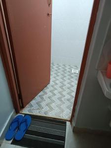 - une paire de tongs bleues dans une salle de bains avec une porte de douche dans l'établissement Epic homes, Secure1 bedroom furnished partment, ample Parking and WiFi available, à Nyeri