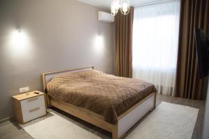 a small bedroom with a bed and a window at Apartment in center of Chisinau in Chişinău