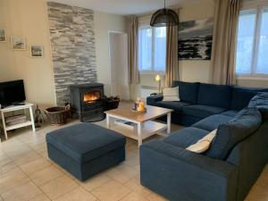 a living room with a blue couch and a fireplace at Maison village, 10 pers, proche de la plage in Audinghen