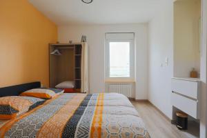 1 dormitorio con cama y ventana en Grande longère familiale pour 4 à 14 personnes, en Le Faouët