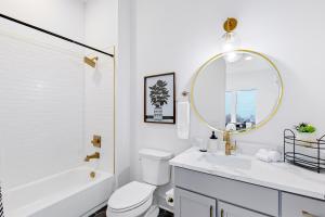 a bathroom with a toilet and a sink and a mirror at Jolene on Main 406 in Nashville