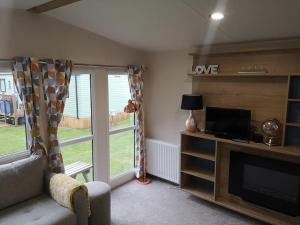 sala de estar con chimenea y TV en Plompton Mill Holiday Home, en Knaresborough