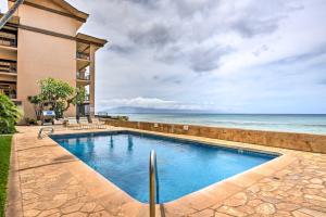 a swimming pool with the ocean in the background at Beachfront Lahaina Condo - Featured on HGTV! in Kahana