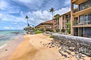 a beach in front of a hotel and the ocean at Beachfront Lahaina Condo - Featured on HGTV! in Kahana