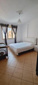 een slaapkamer met een groot bed en een tegelvloer bij Sea view apartment 105m² in Vlore in Vlorë
