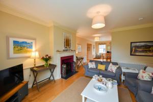 Una sala de estar con un sofá y un televisor. en Garden Cottage, en Stranraer