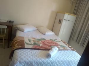 a bedroom with a bed with a pillow and a refrigerator at Hotel Do Oeste in Palmitos