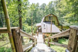 a wooden bridge leading to a house in the woods at Edward - The Hut in Acworth