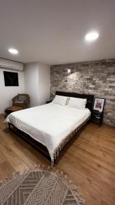 een groot bed in een kamer met een bakstenen muur bij סוויטת סטודיו במתחם נוֺגה in Tel Aviv