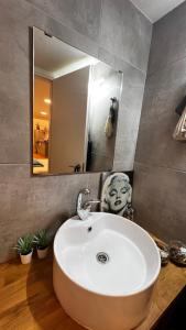 a bathroom with a white sink and a mirror at סוויטת סטודיו במתחם נוֺגה in Tel Aviv