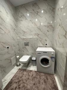 a bathroom with a washing machine and a toilet at Apartment in center of Chisinau in Chişinău