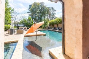 a swimming pool with an orange umbrella next to a house at Villa Flora in Marietta