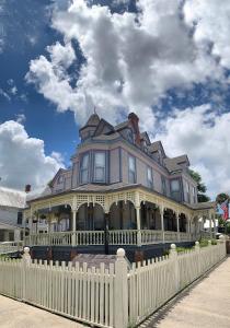 a large house with a white picket fence at Grand Gables Inn in Palatka
