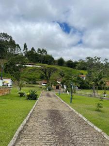 um caminho de paralelepípedos num parque com uma colina em Solar Azul Pousada Boutique em Miguel Pereira