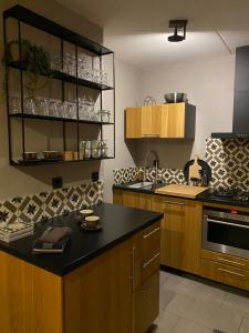 a kitchen with wooden cabinets and a black counter top at Huusje18 in Nunspeet