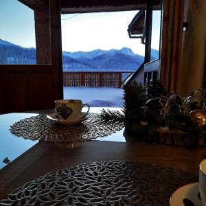 a cup of coffee sitting on a table in front of a window at Holiday Home Krzysztoforow in Zakopane