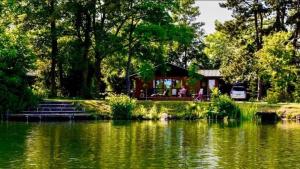 a cabin by a pond with a house at Maple Lodge 11 Hot Tub & Sauna in York