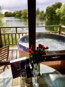 uma mesa com um vaso de flores e uma banheira em Holly Lodge 12 Hot Tub em York
